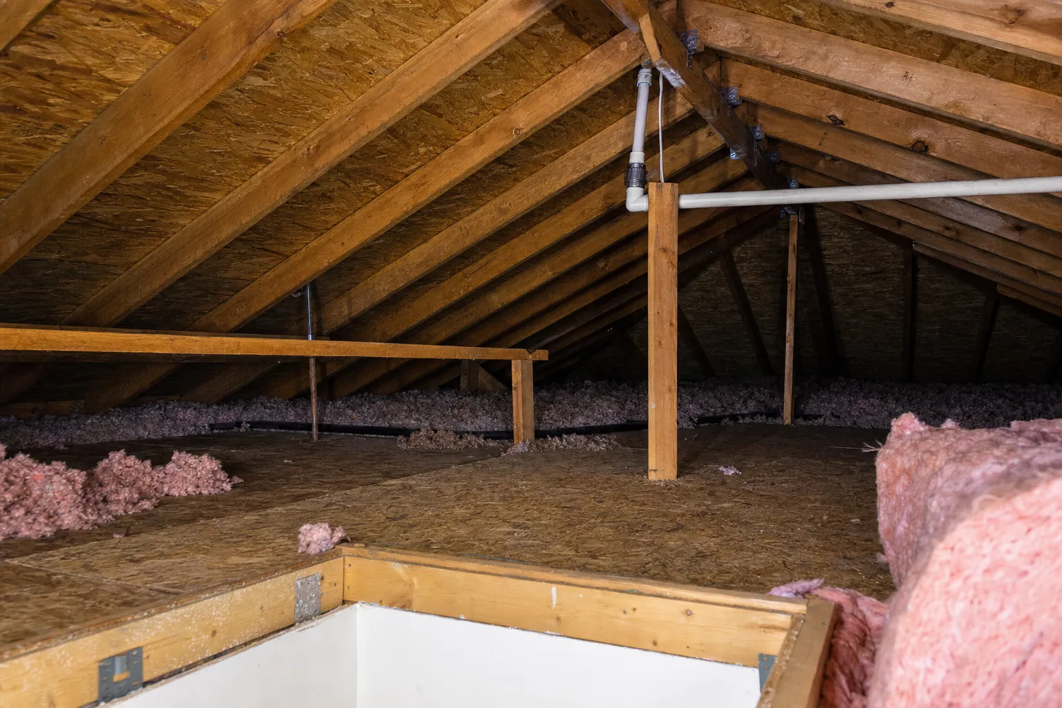Attic framing and plumbing line viewed during a safe visual inspection