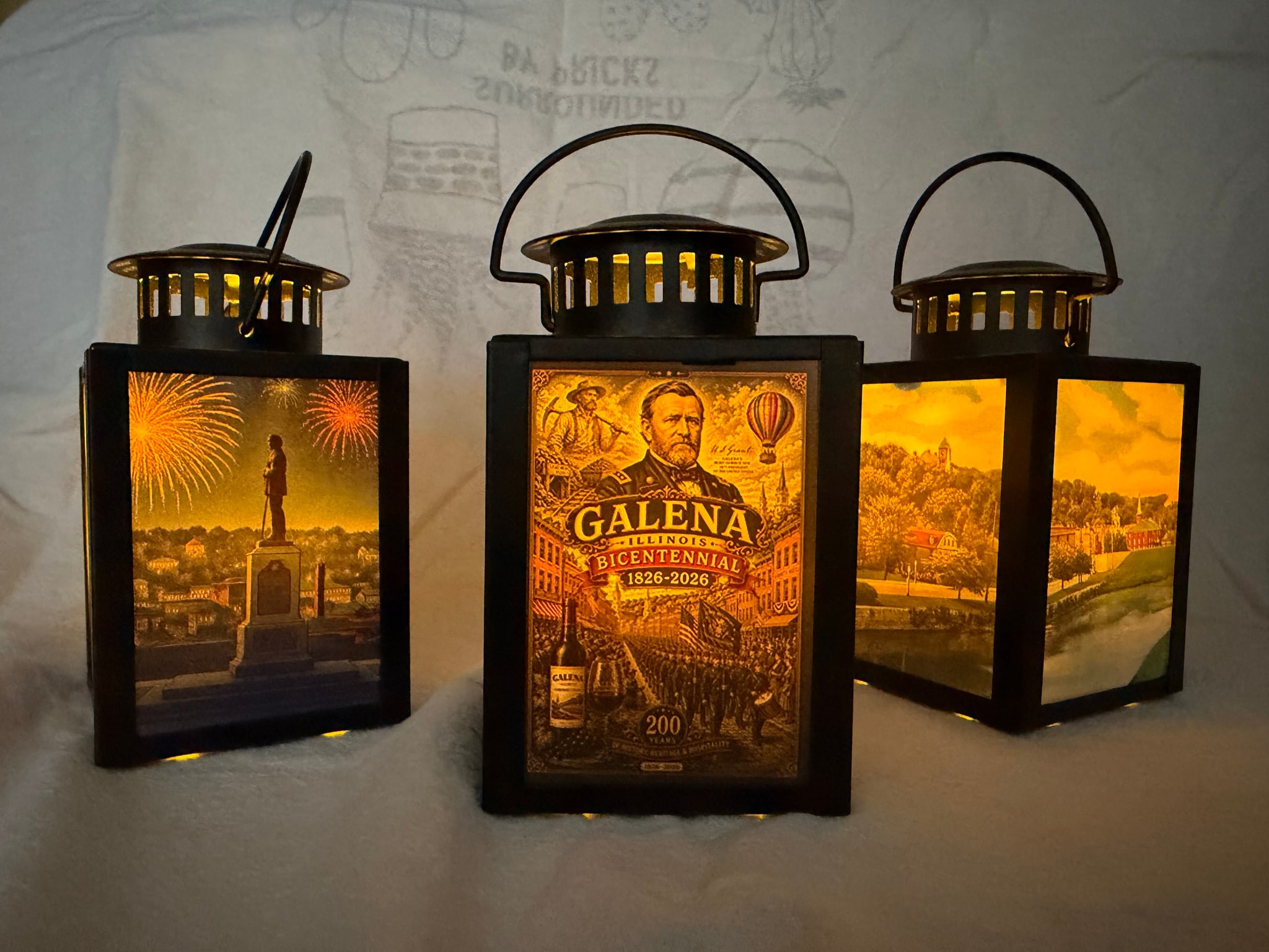 Three illuminated Galena Christmas Company lanterns on a white backdrop