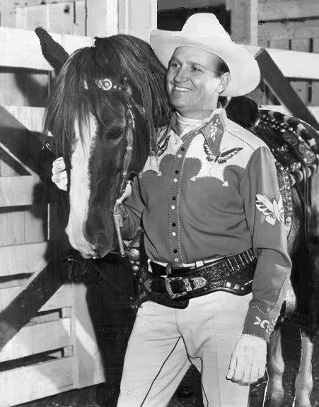 Gene Autry in cowboy clothing beside his horse Champion, 1950
