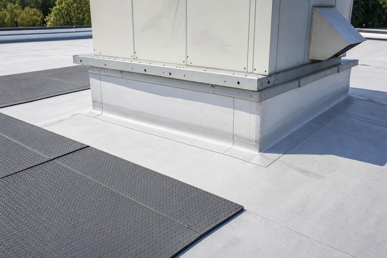 Commercial rooftop HVAC curb with intact flashing and protective walk pads