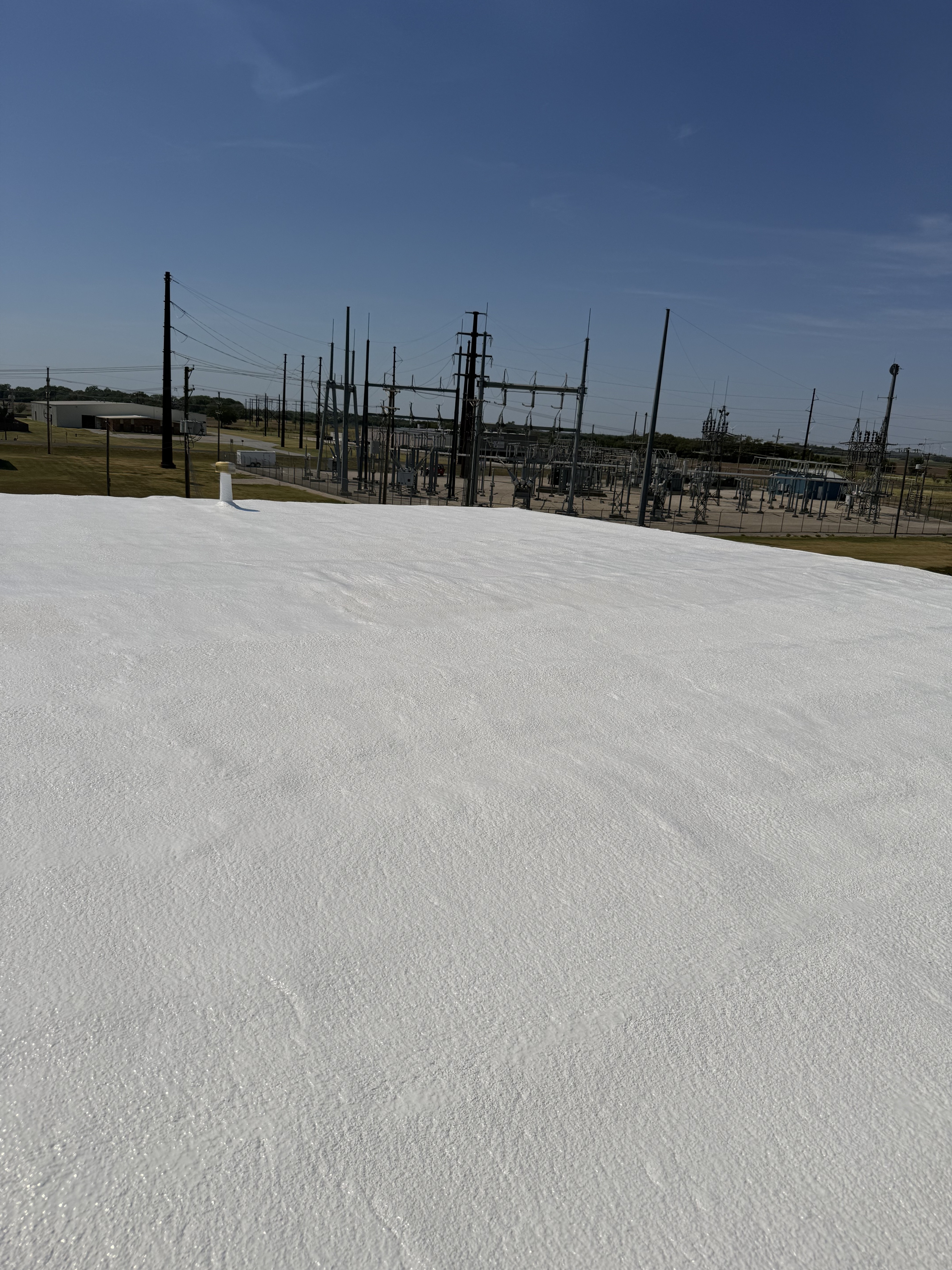 Completed white commercial roof restoration coating
