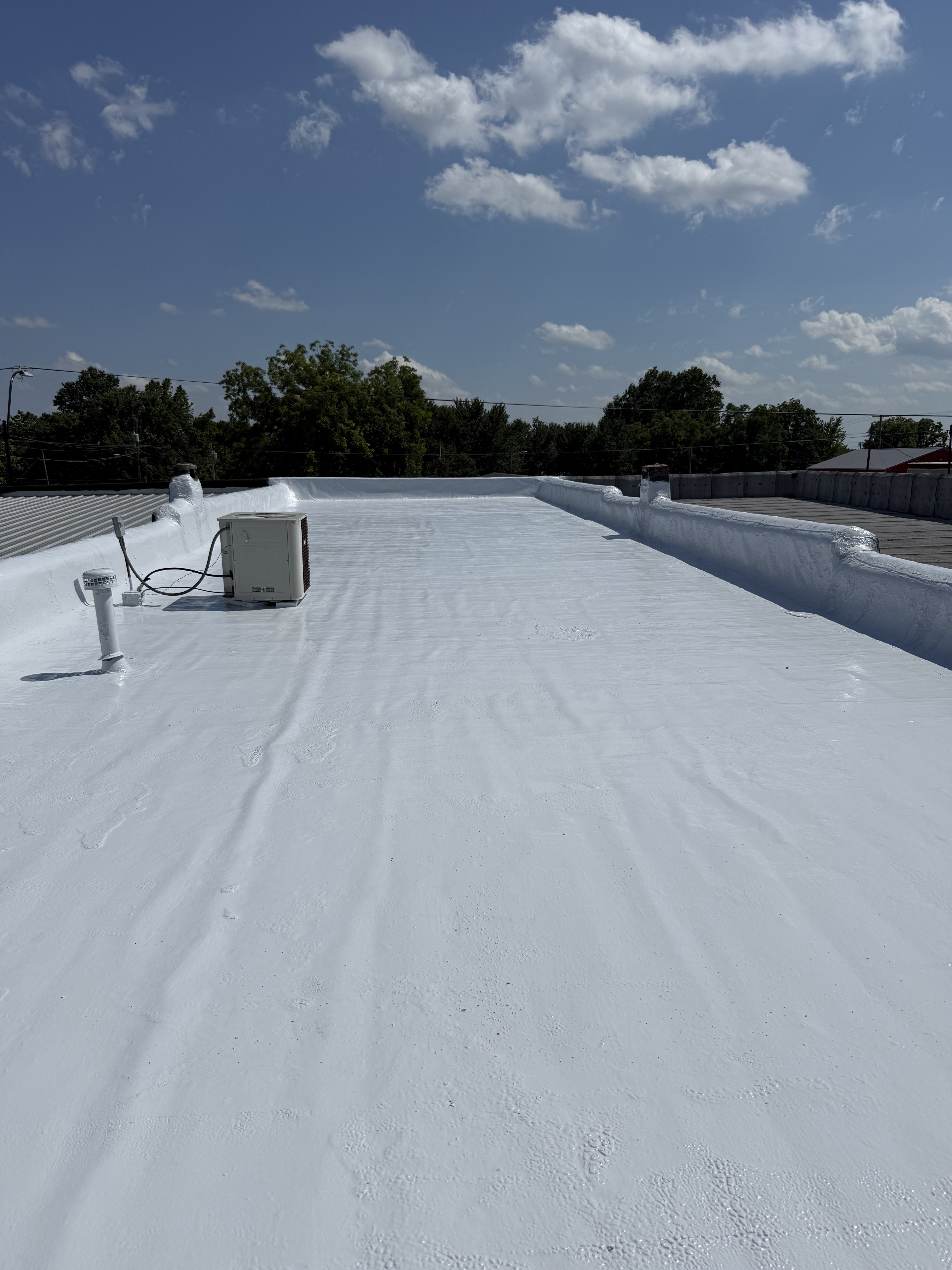 Restored white commercial roof around rooftop equipment