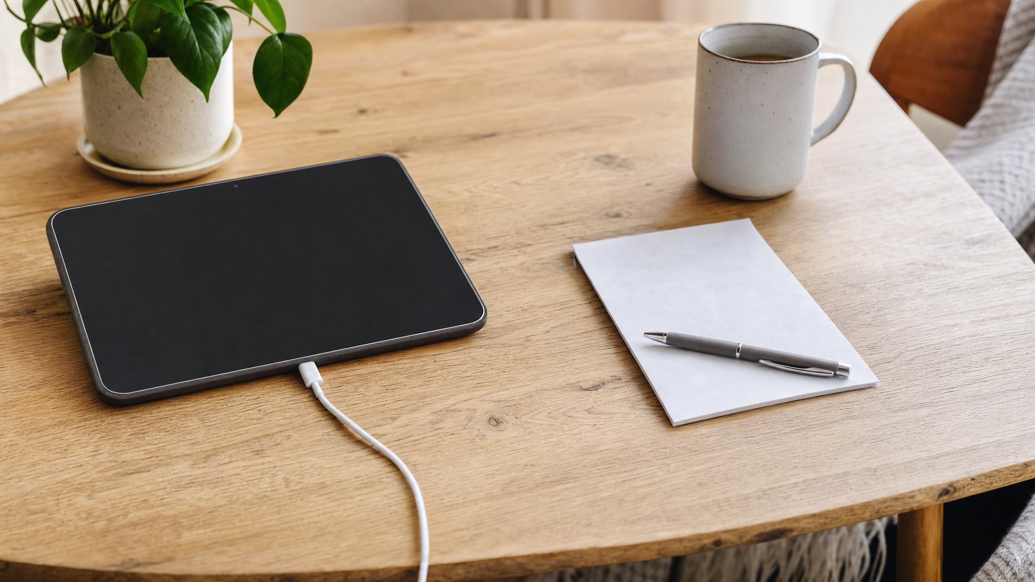 Tablet, appointment note, and charger prepared on a table at home