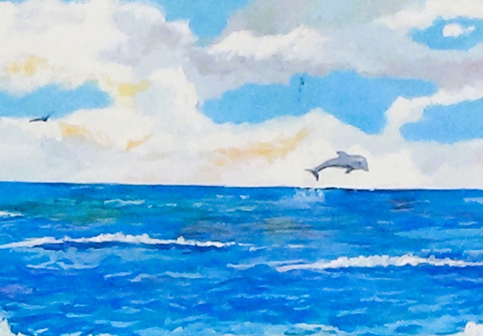 A dolphin is jumping into the ocean while a woman watches from a tropical beach., view 4