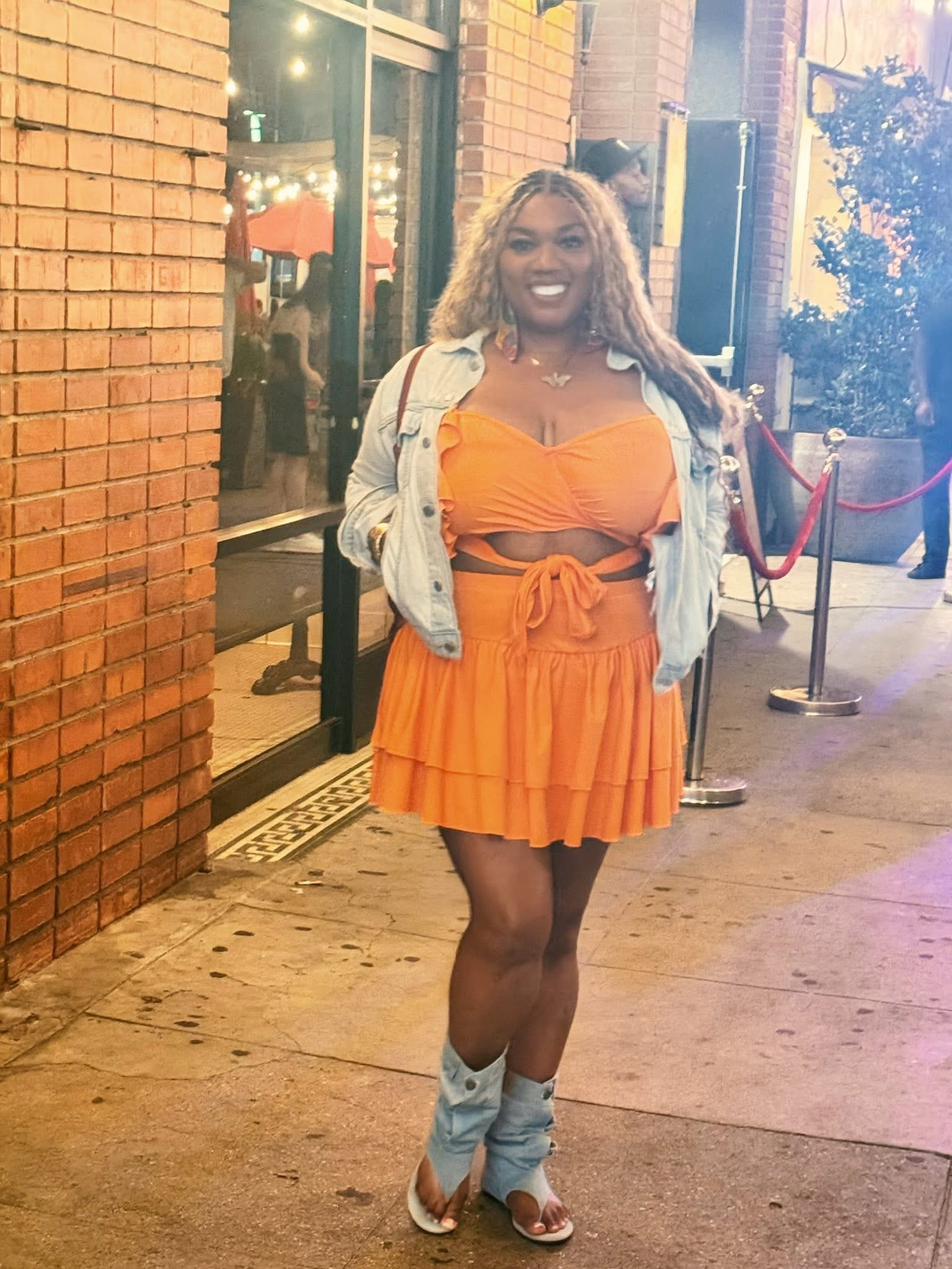 Lysette Titi in an orange look outside at night