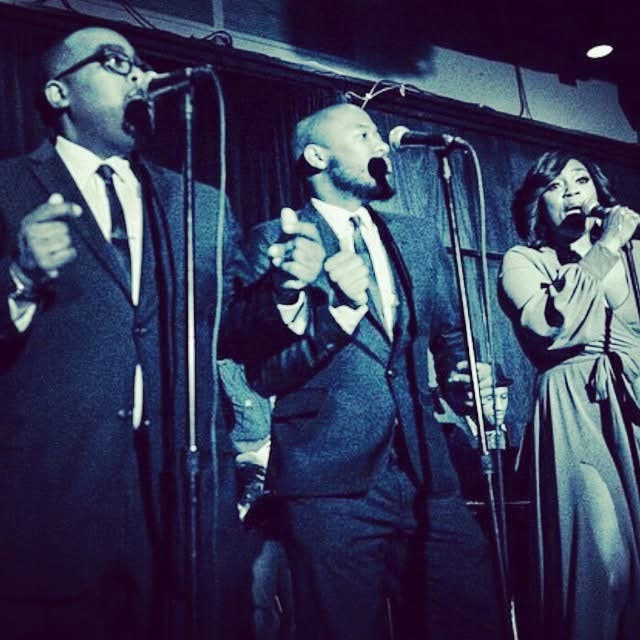 Archival stage performance with vocalists at microphones