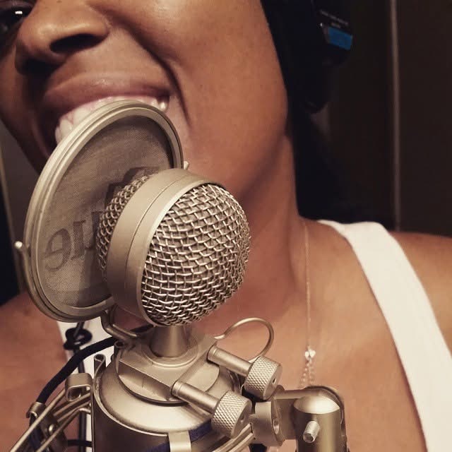 Lysette Titi singing into a studio microphone