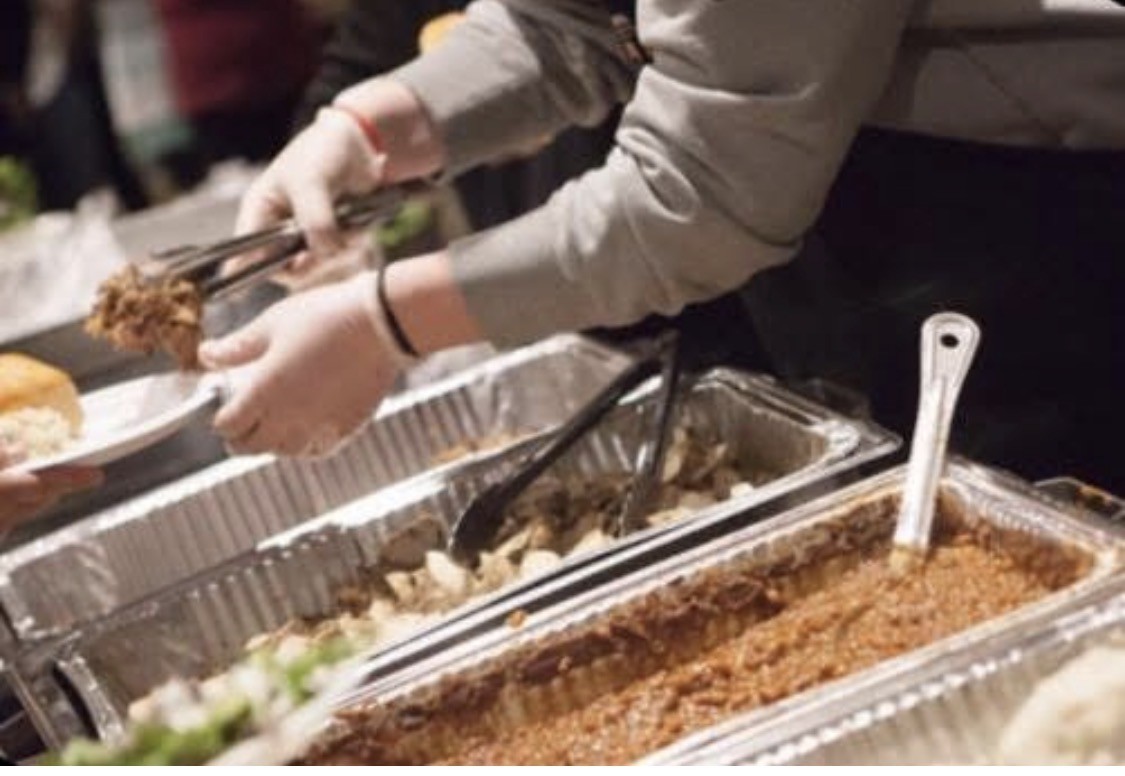 A guest being served barbecue at a Papaw's catered event