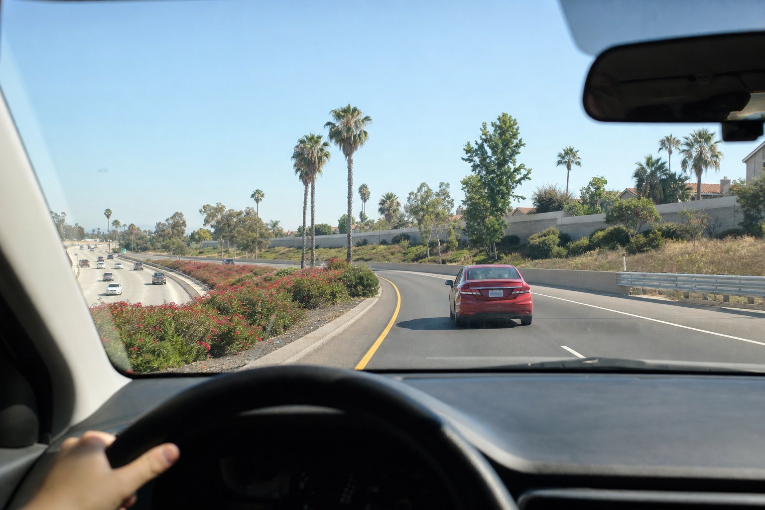 A red sedan entering a Southern California freeway