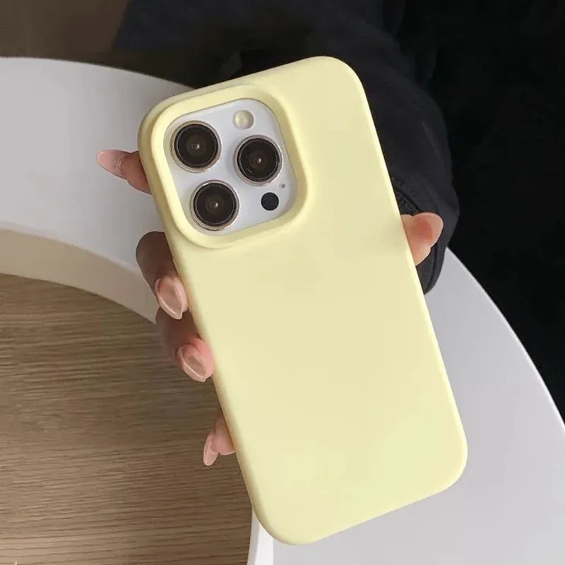 A pale yellow Snap and Grip silicone iPhone case held in a hand