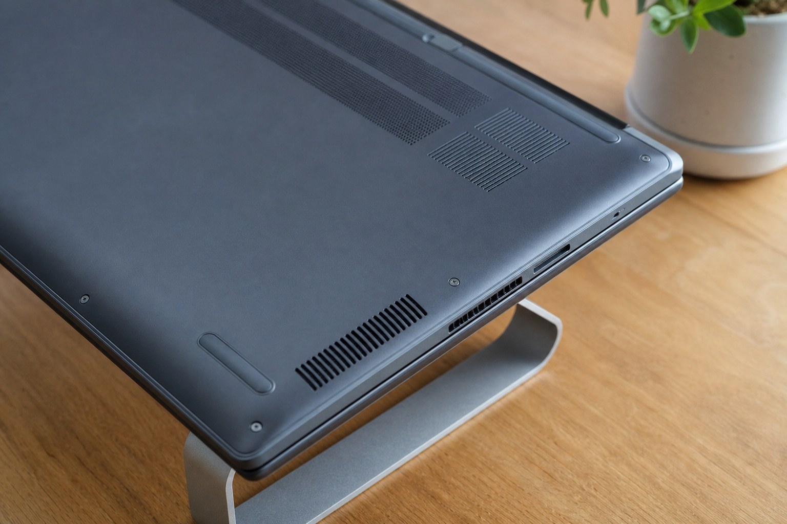 Underside of a laptop raised on a stand with cooling vents unobstructed