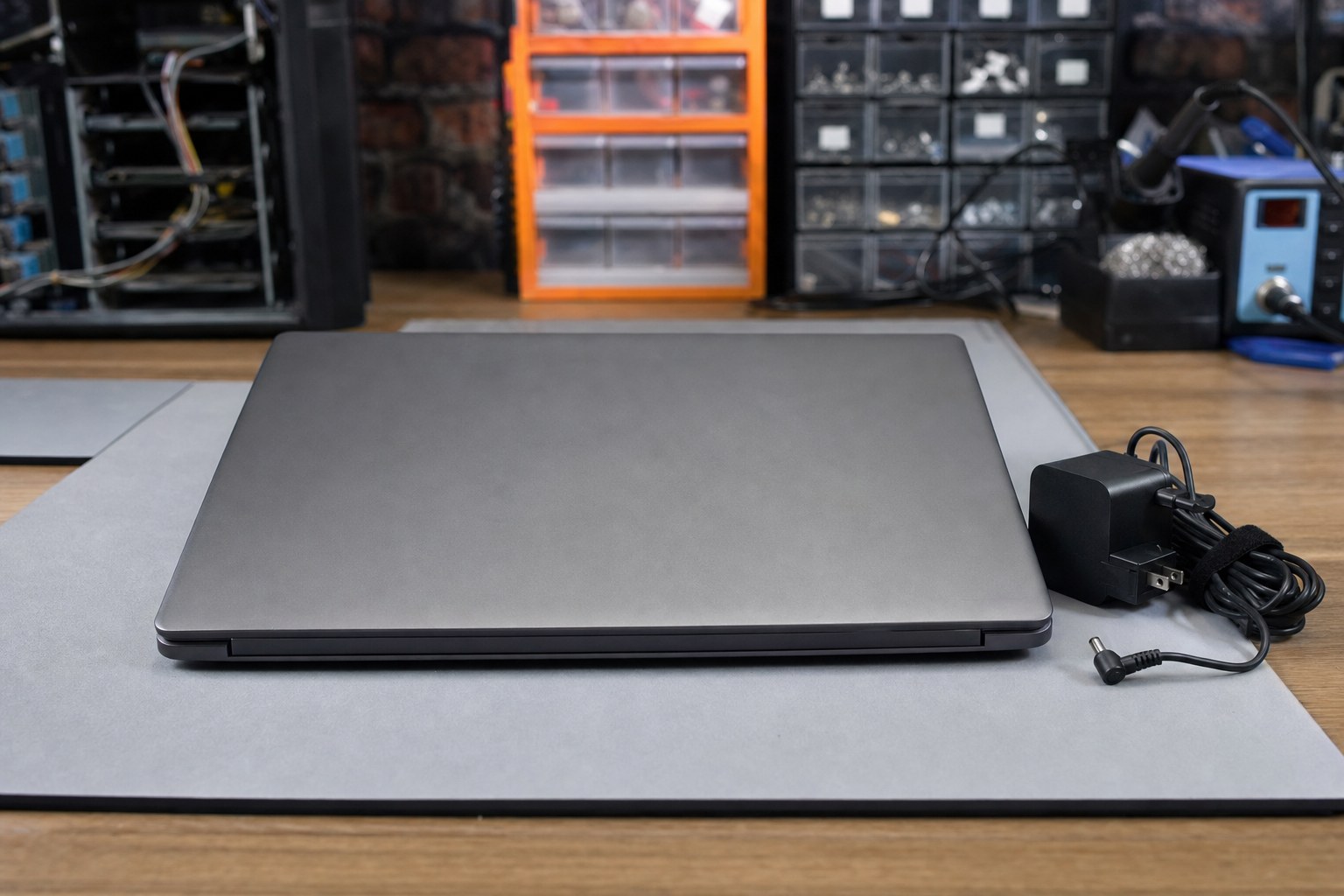 Powered-off laptop and unplugged charger on a repair bench