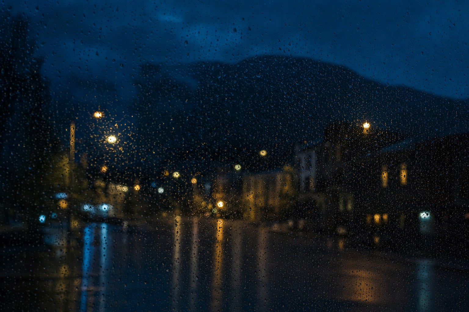 Rain on glass looking onto a night street
