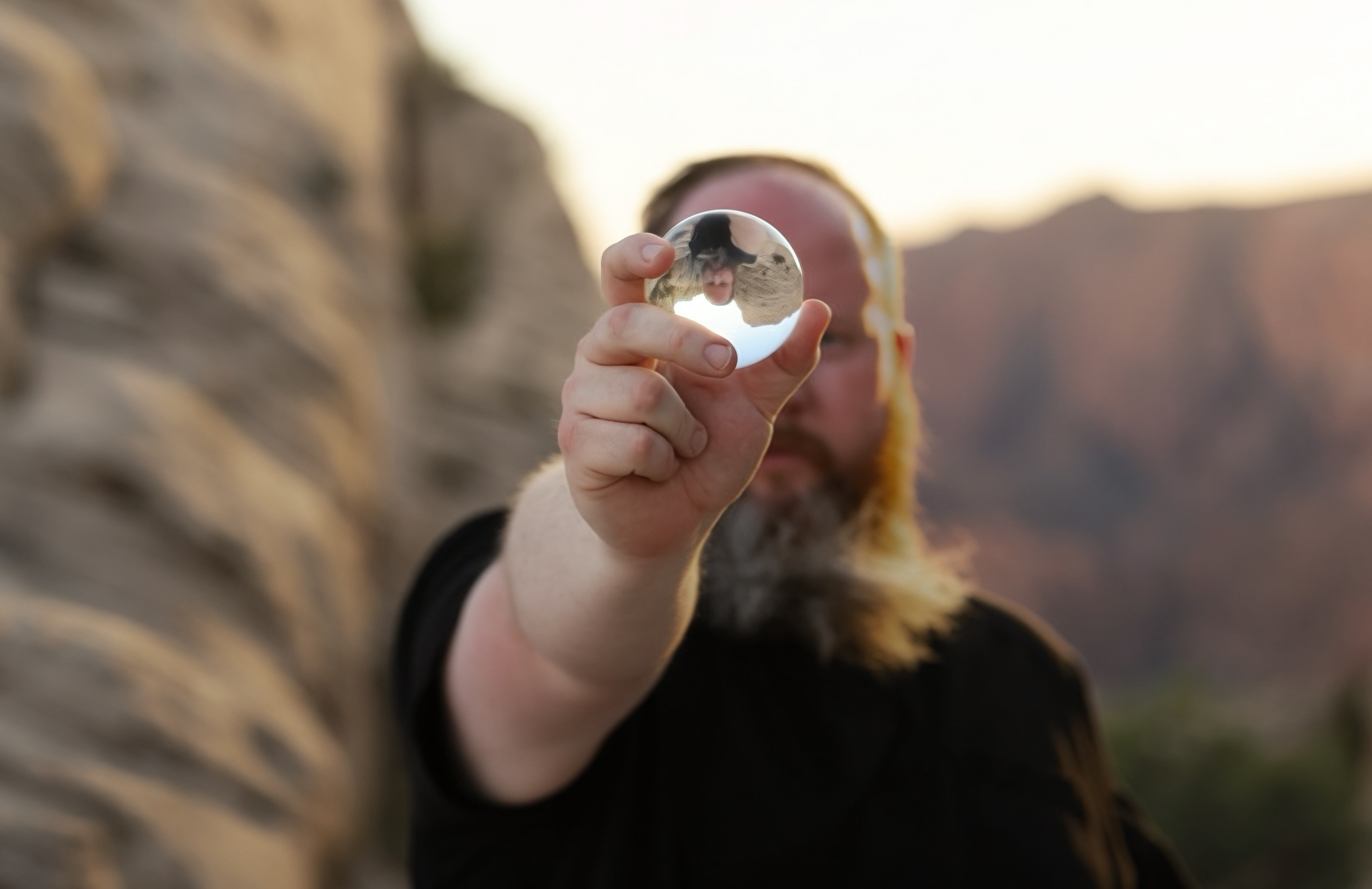 Morgan holding a crystal against a desert landscape
