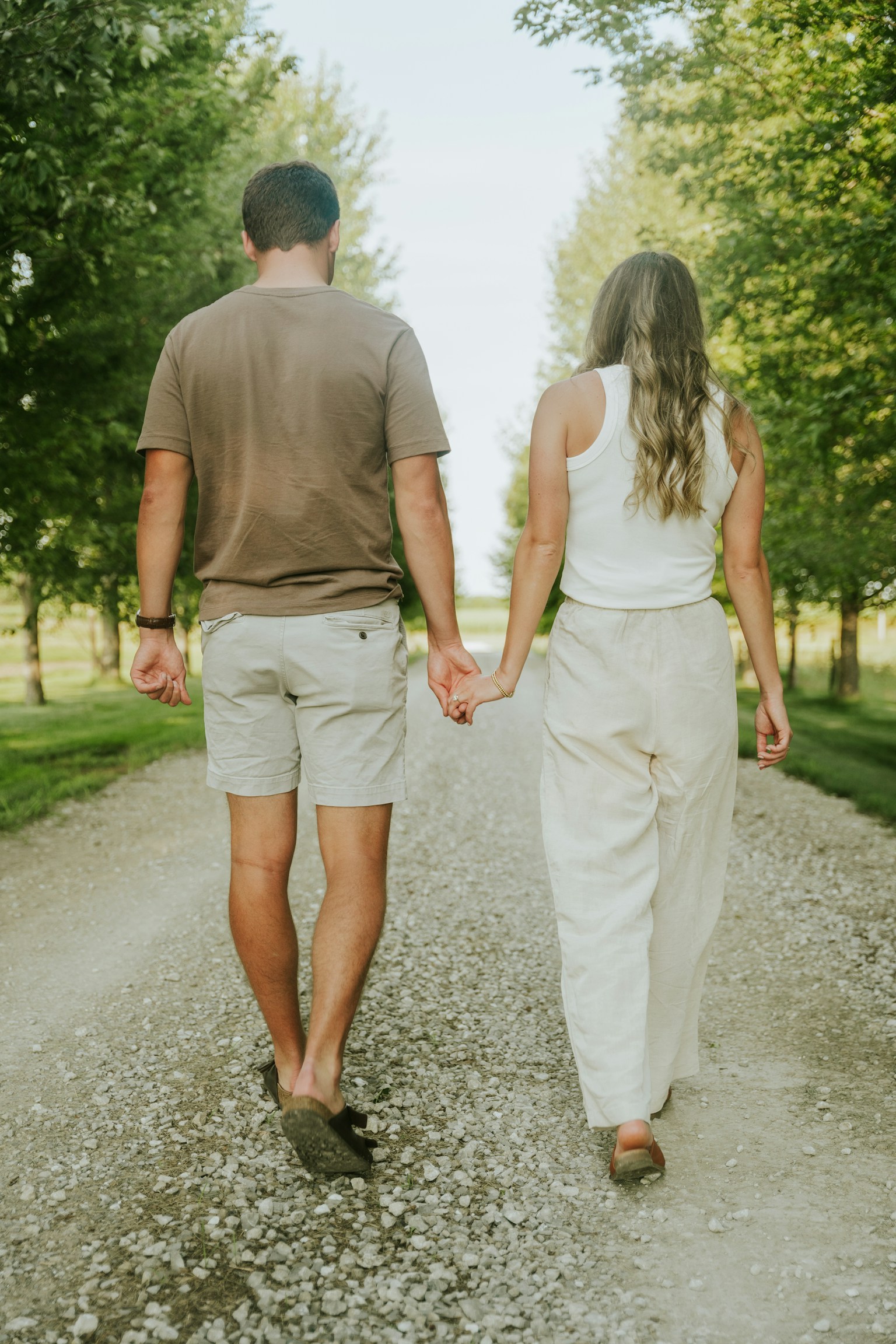 A couple walking together on a tree-lined path