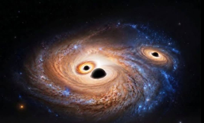 Three black holes glowing in a newborn galaxy