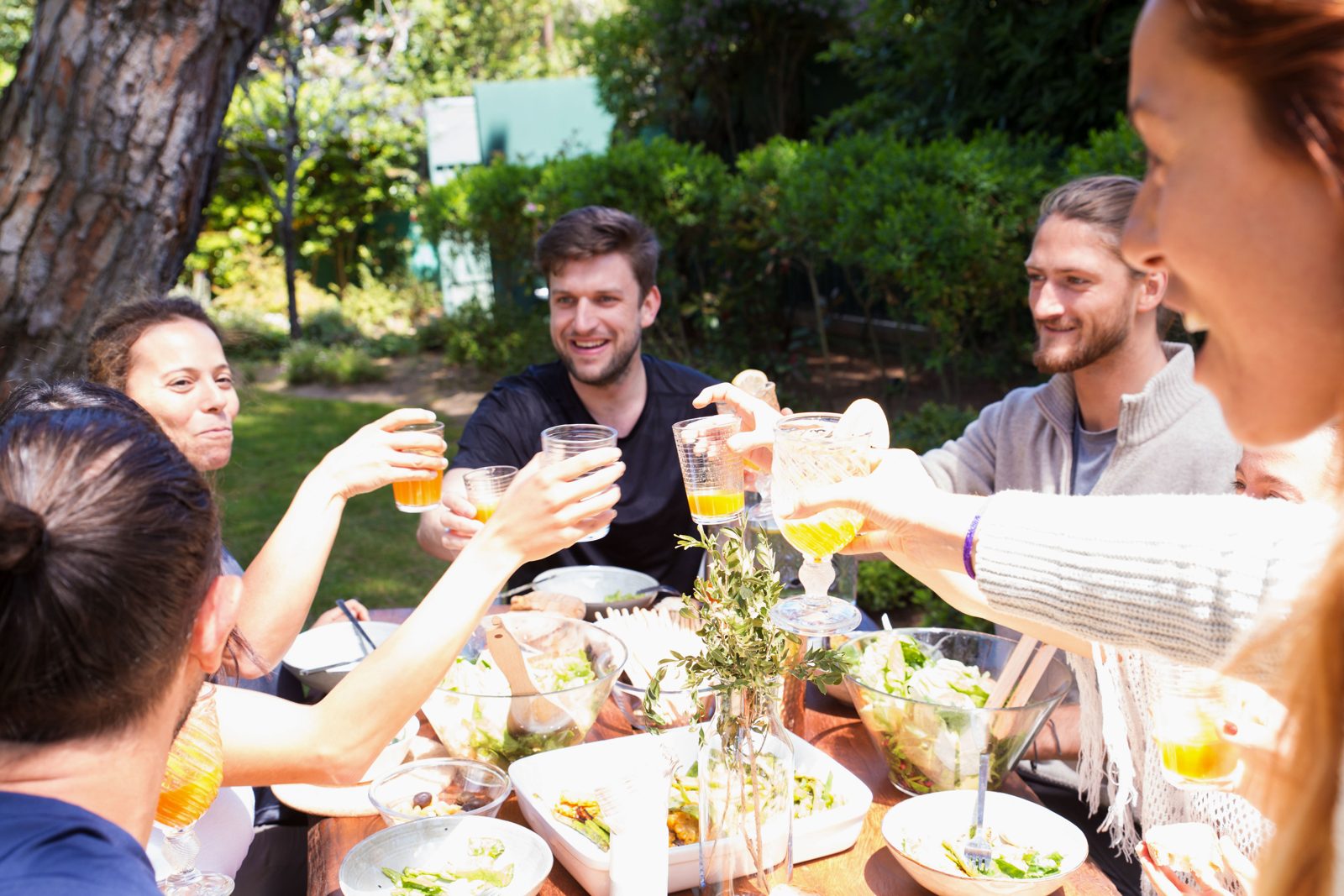 A small group enjoying drinks and a meal at an outdoor gathering