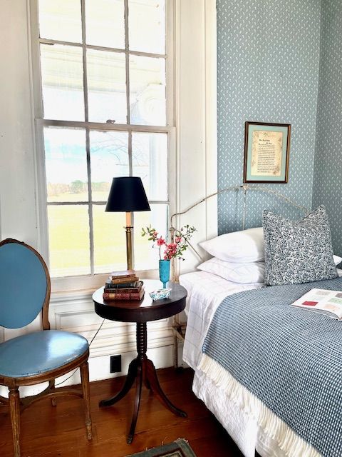 A blue chair and bedside table in a guest bedroom