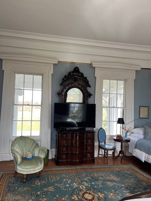 An antique dresser and seating in a guest bedroom