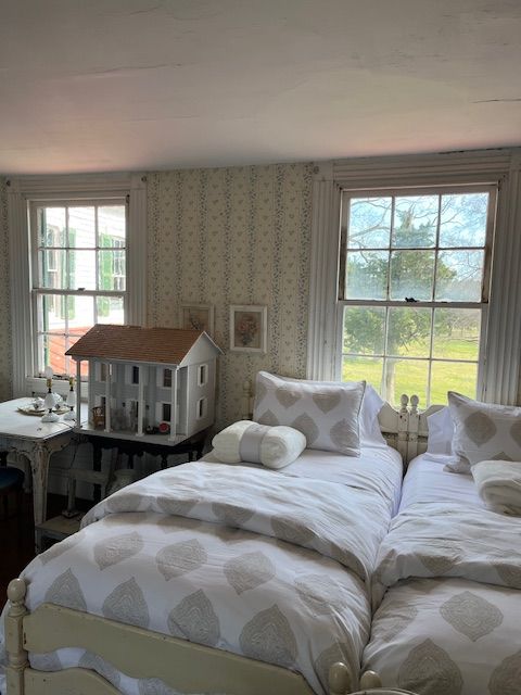 Twin beds and a dollhouse in a guest bedroom