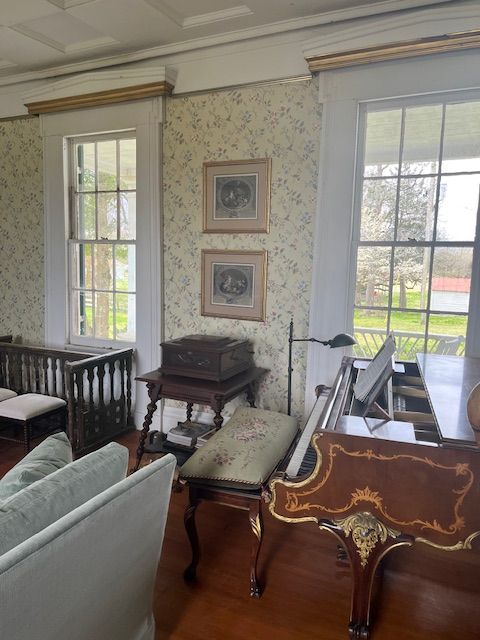 A writing desk and seating beside the bedroom windows