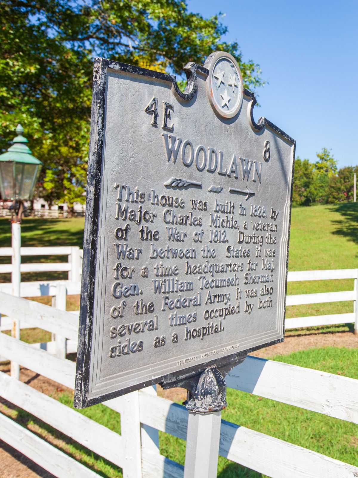Woodlawn historic marker beside the white estate fence