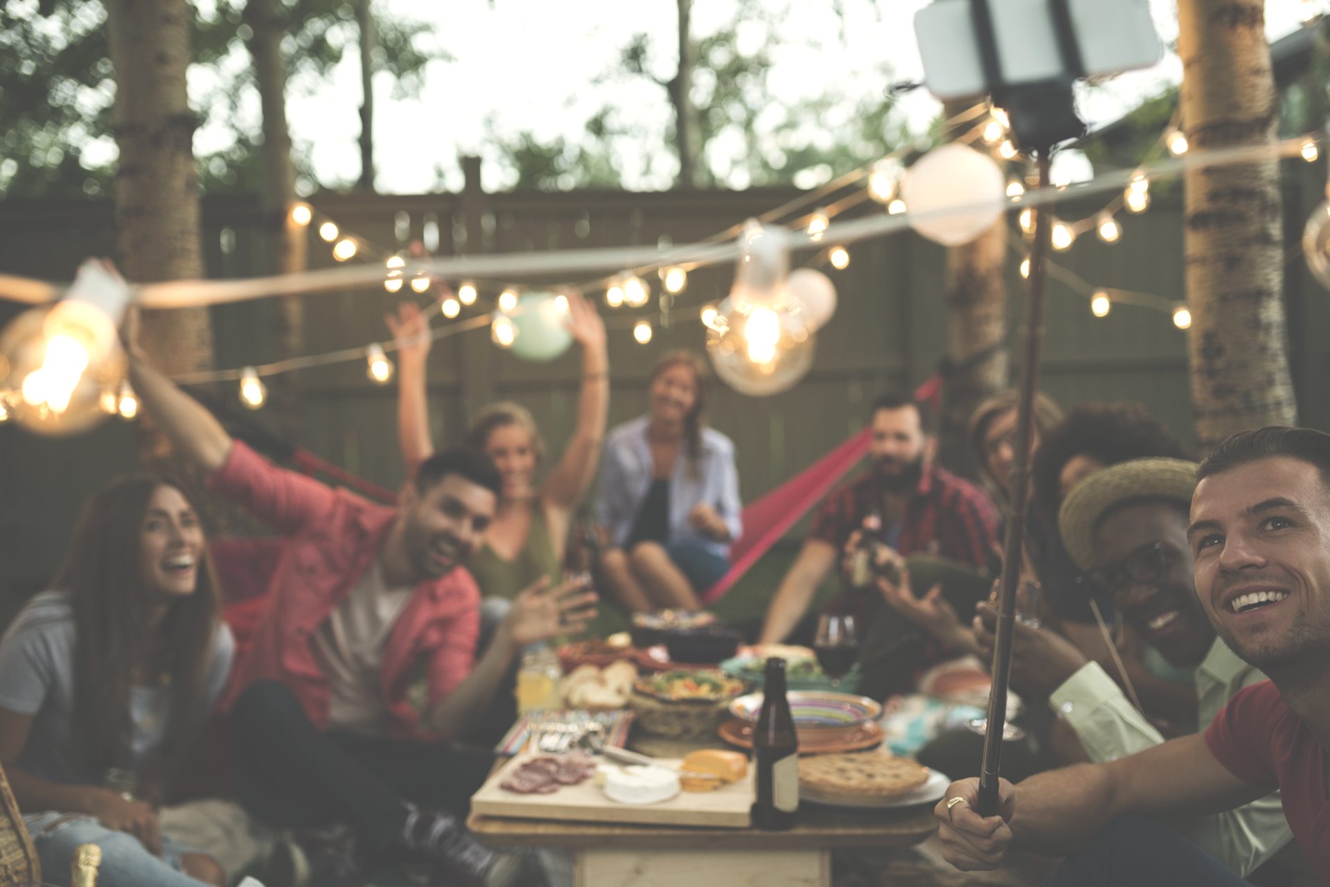 Friends celebrating outdoors beneath string lights
