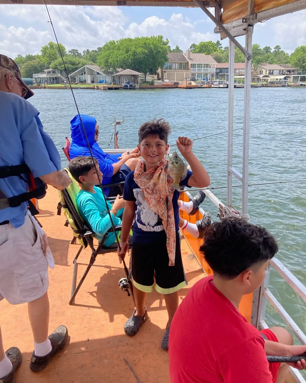 Young angler holding a fish on a covered Lake Conroe fishing boat. Lake Conroe Fishing Guide - Billy Mills