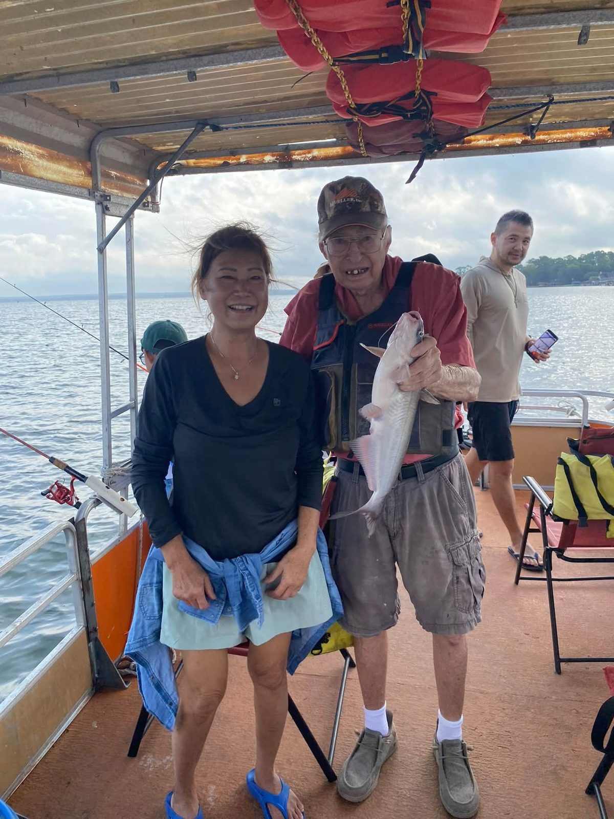 Two guests with Billy and a catfish aboard the boat