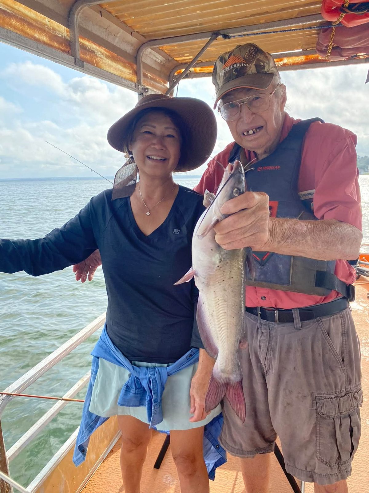 A smiling guest with Billy and a catfish