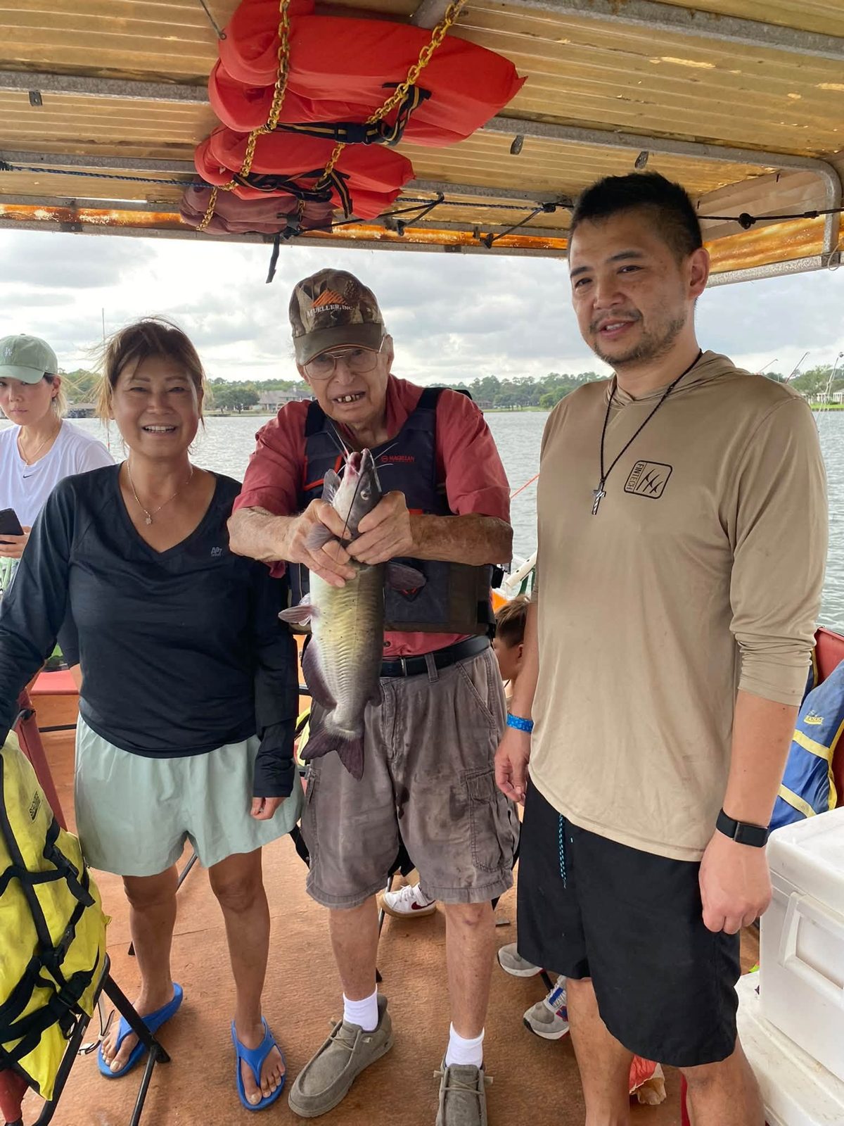 Family members with Billy and a catfish aboard the boat
