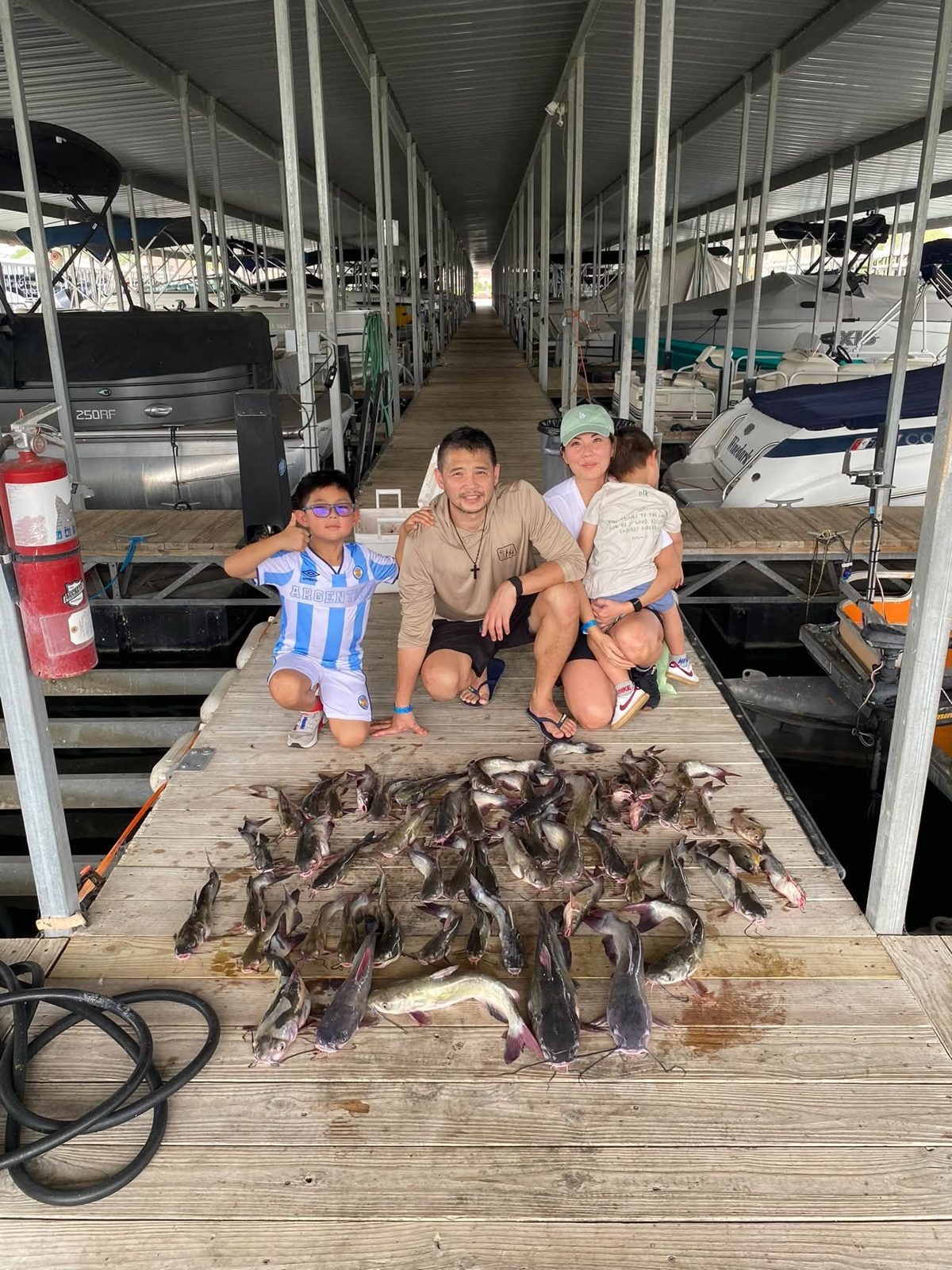 Family gathered behind their catfish catch at the marina. Lake Conroe Fishing Guide - Billy Mills