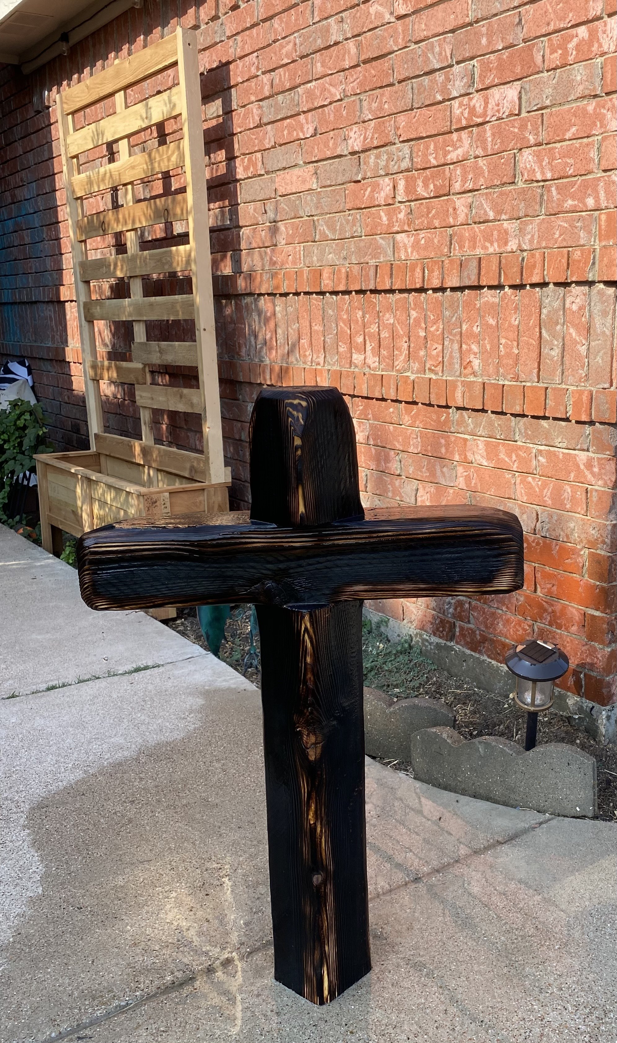Charred handmade wooden cross displayed outdoors