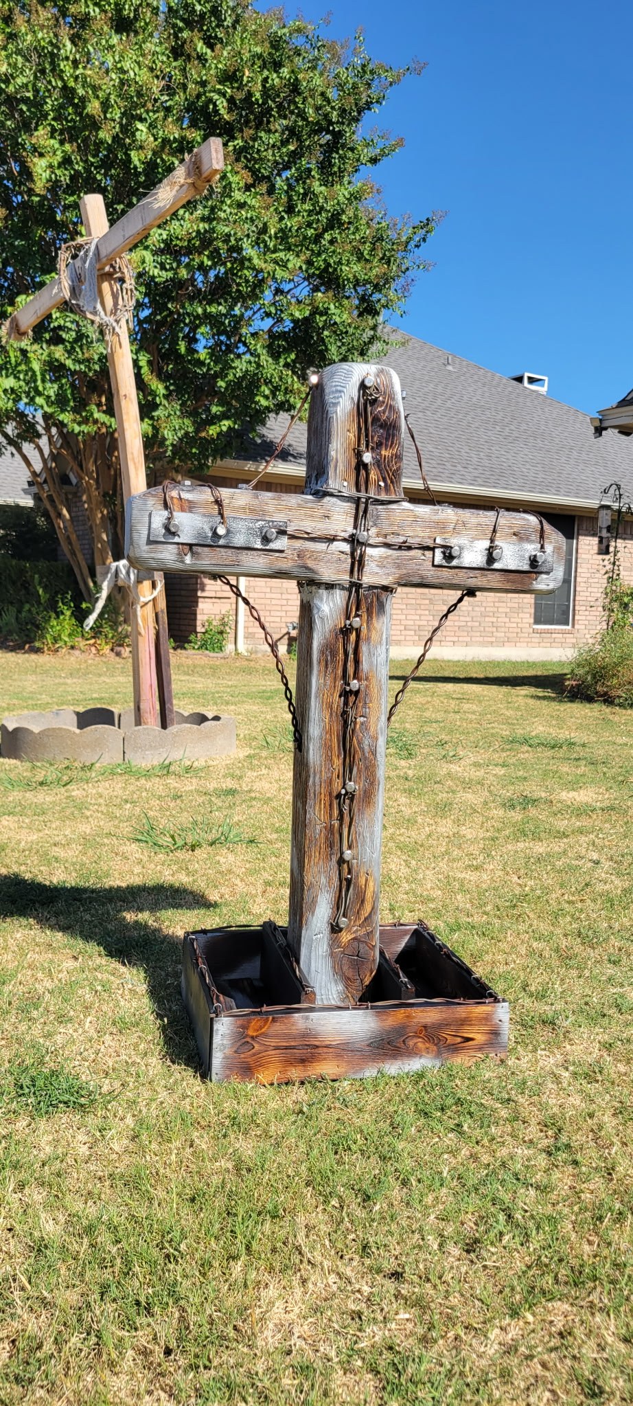 Handmade outdoor wooden cross with weathered finish, iron bolts, and chain details