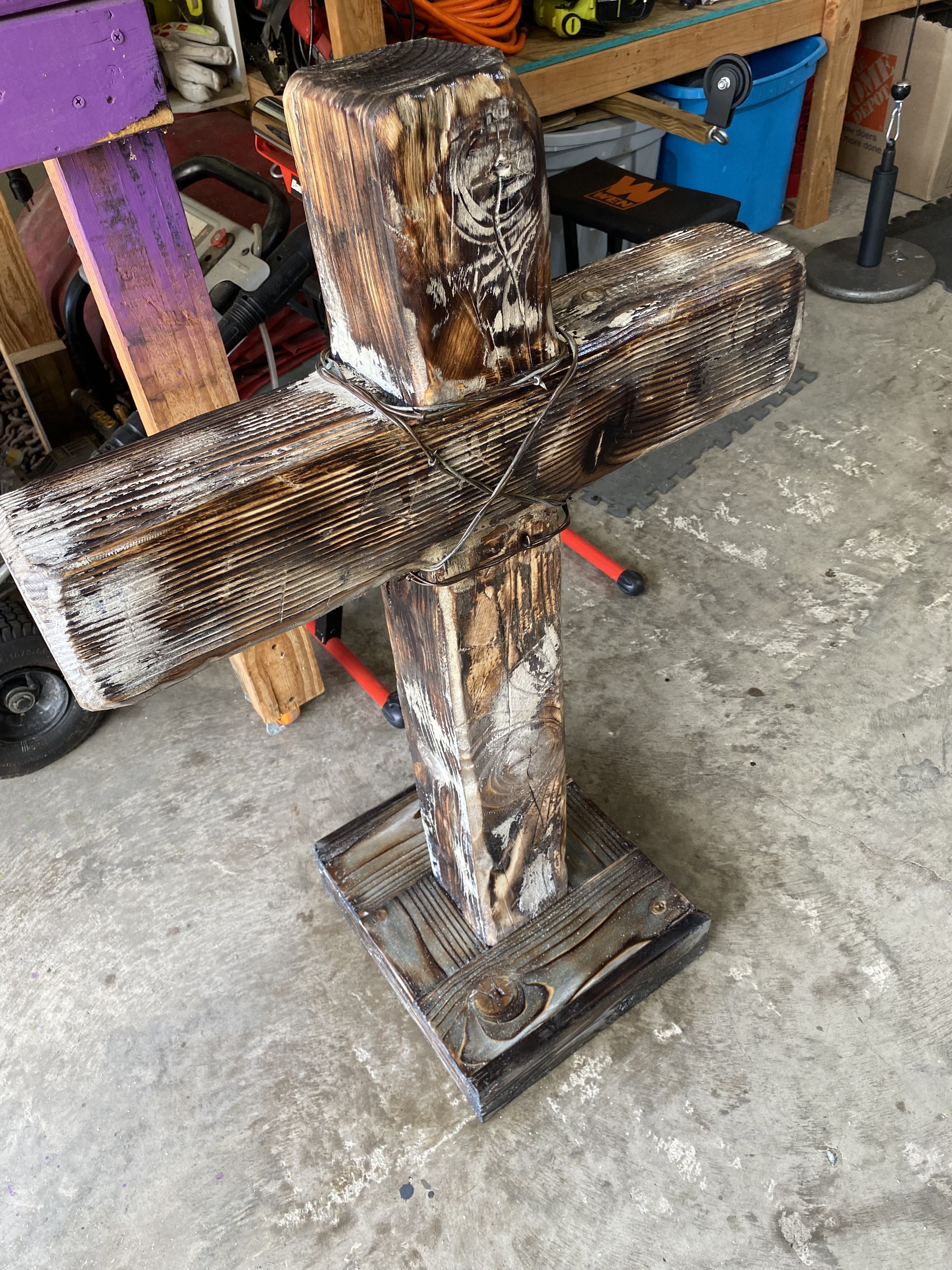 Weathered handmade wooden cross with barbed wire detail