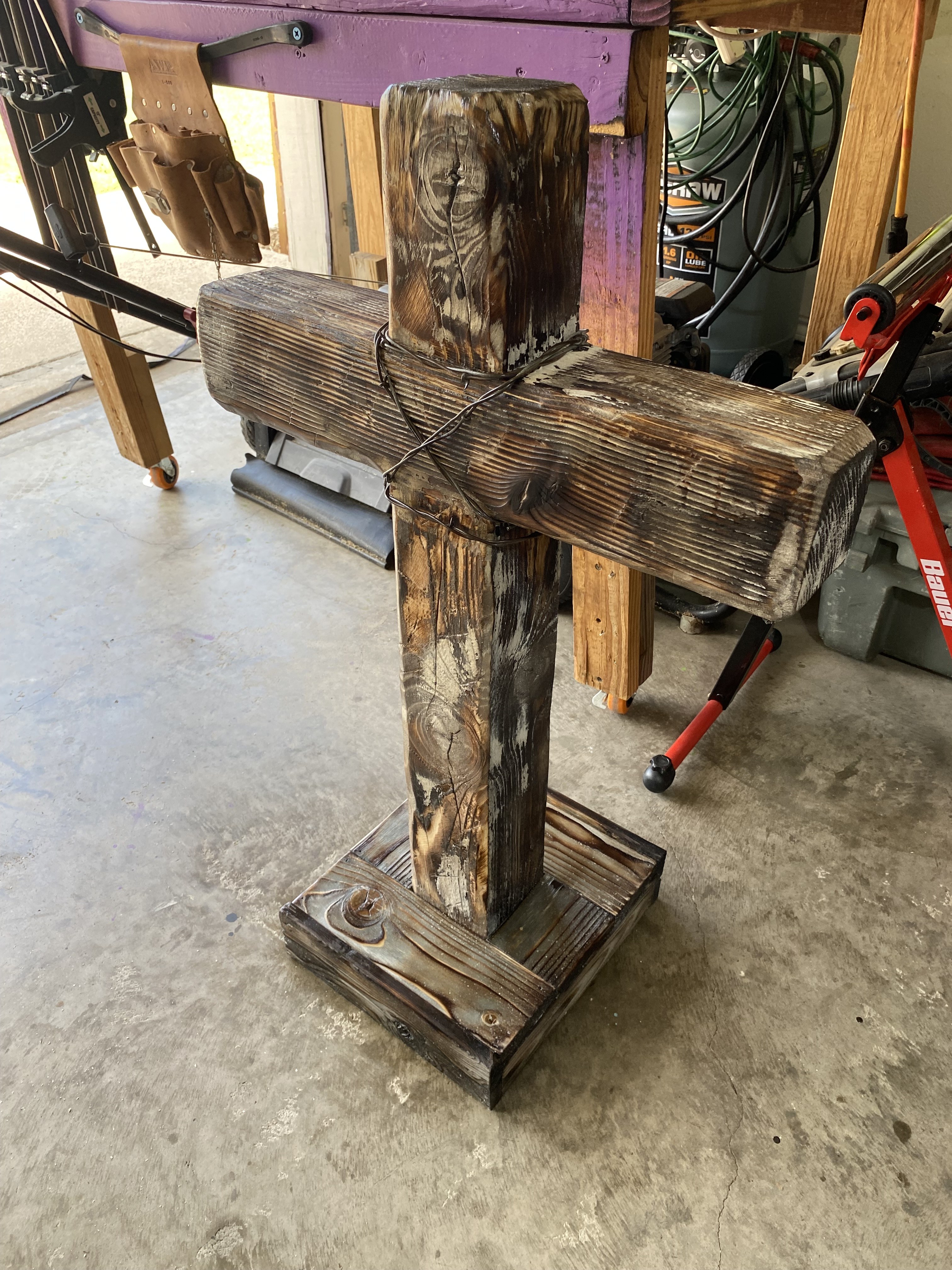 Weathered handmade cross displayed in a workshop