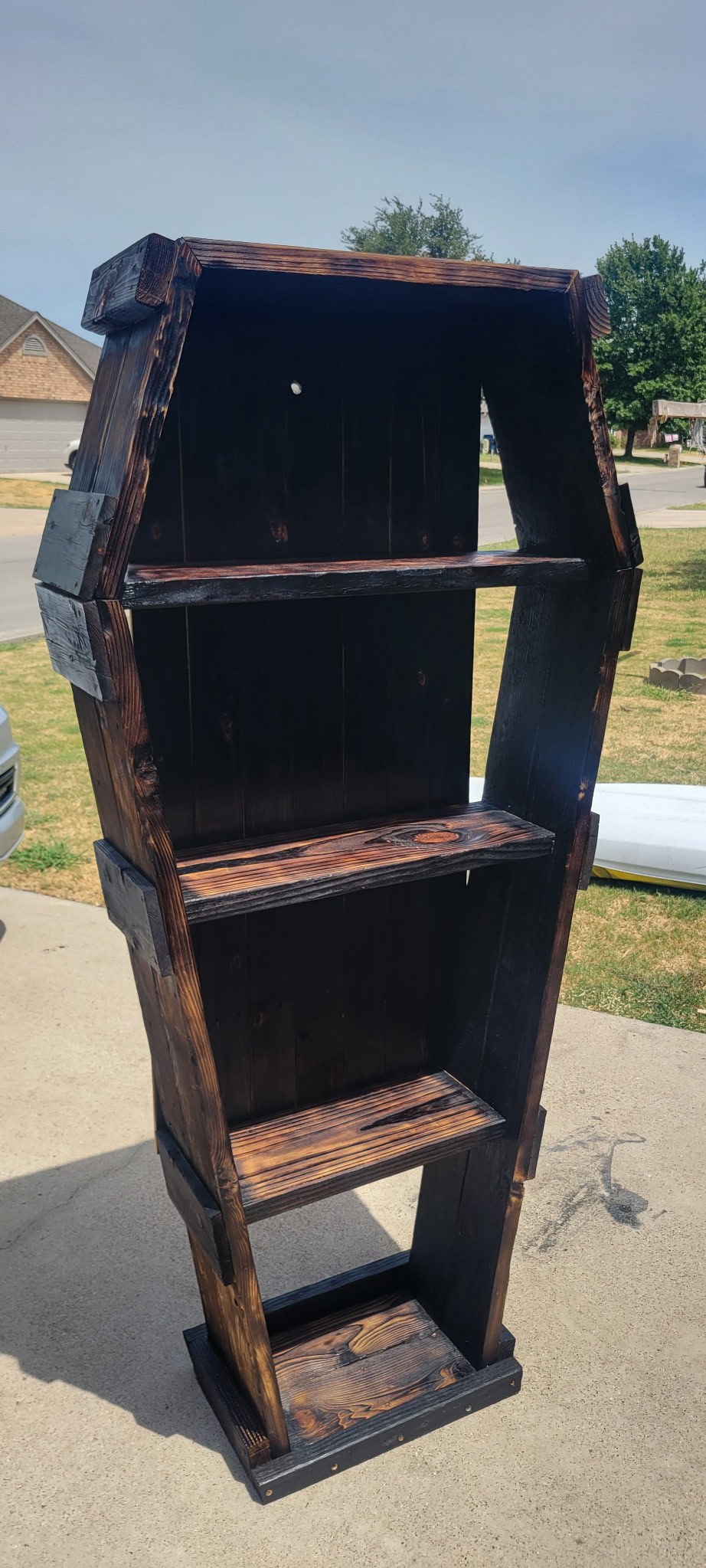 Front view of a handmade coffin-shaped shelf in progress