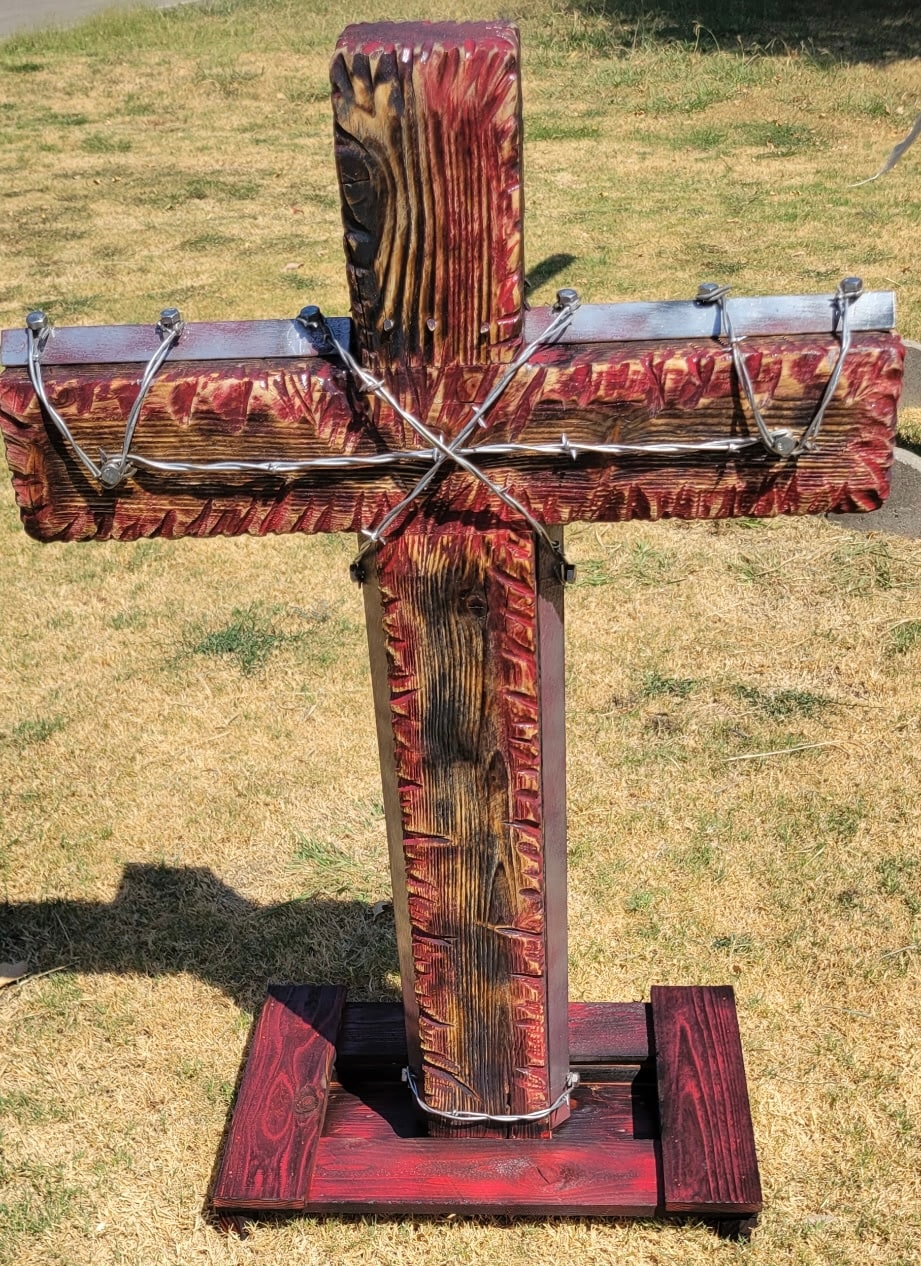 Finished hand-carved wooden cross with red and black details