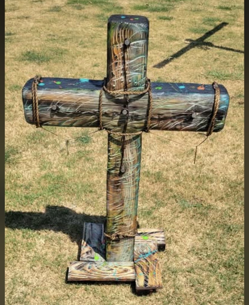 Colorful handmade wooden cross displayed outdoors