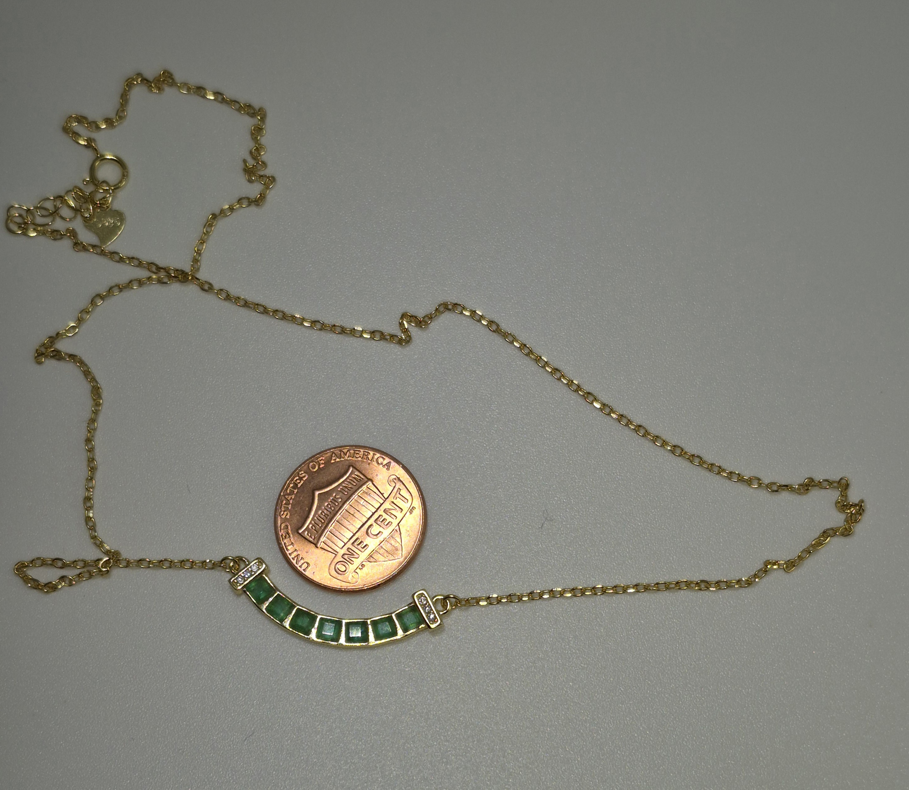 Natural Emerald Chain Necklace shown beside a penny for scale