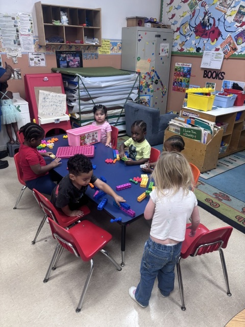 Children building and playing together at a classroom table