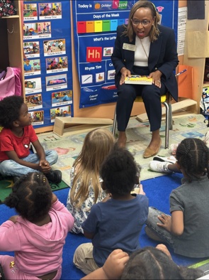 An adult sharing a picture book with children at Peek-A-Boo Learning Center