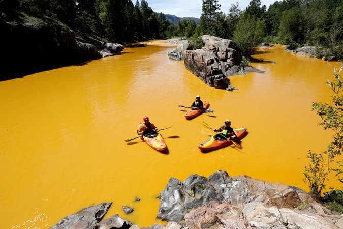 People kayaking in the Animas River near Durango, Colo., last Thursday, in water colored from a mine waste spill. The river is now closed indefinitely, with visitors warned to stay out. Credit Jerry Mcbride/The Durango Herald, via Associated Press