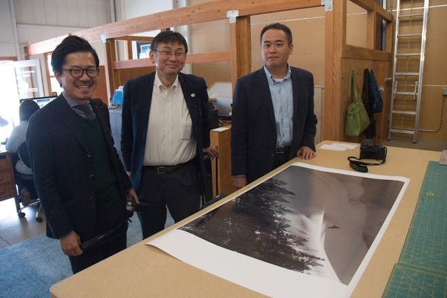 Panasonic Lumix executives Shinji Watanabe, Henri Nishikawa and Yasuhide Yamada take time out to review one of Daniel's newest print newest print releases "Raven Spirit" at the Natural Exposures office in Bozeman, Montana