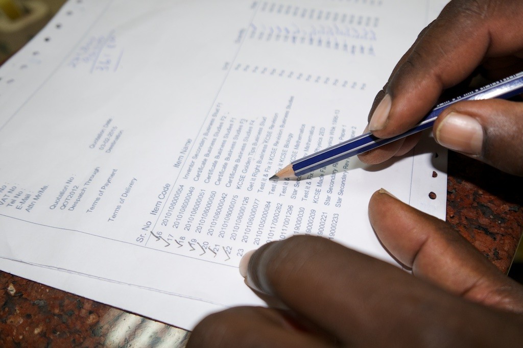 Henry checks each title and ticks them off as they are run through purchase process. Kenya, Lumix LX100