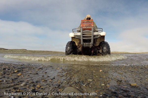 Denver Holt rides his four wheeler across the mouth of salt water estuary along the coast of the Beaufort Sea. Individual still frame taken from video from GoPro Black Edition.