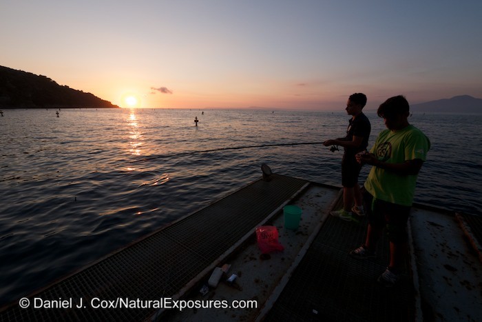 A pair of young fisherman working on their capture skills on the pier of Sorrento, Italy