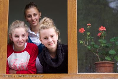 Three beautiful young girls pose for the camera at their school in the village of Budesti, Romania.