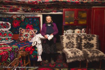 Mrs. Opris inside her house in the colorful living room where she is showing dresses she makes for sale. Sarbi, Romania