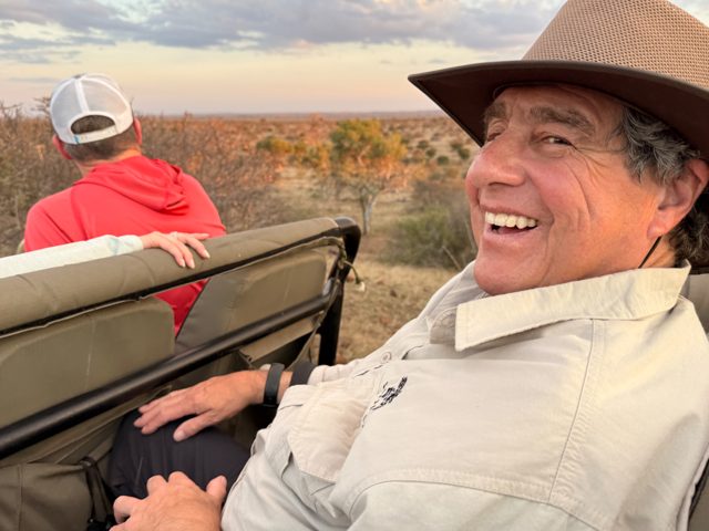 Smiling NE Explorer riding in a safari vehicle